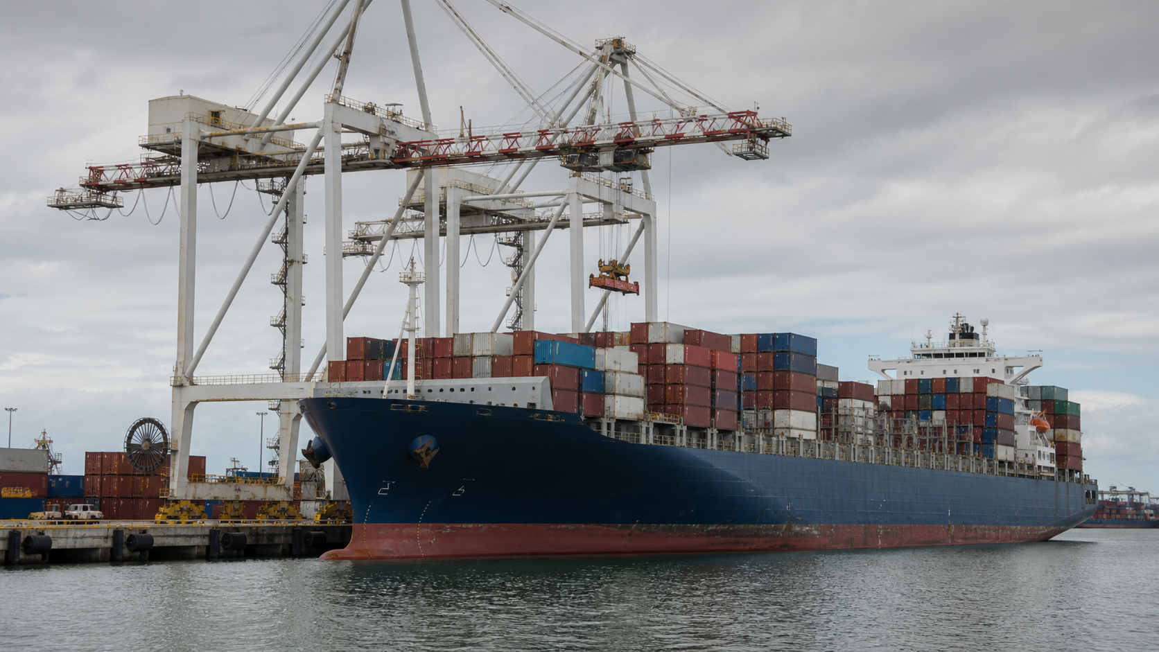Large container vessel being worked by gantry cranes at a commercial port